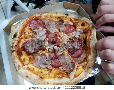 Man hand holding a pizza out of the box