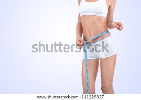Woman measuring waist of perfect body by centimeter