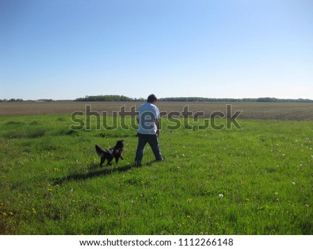 A man and his dog survey the land.