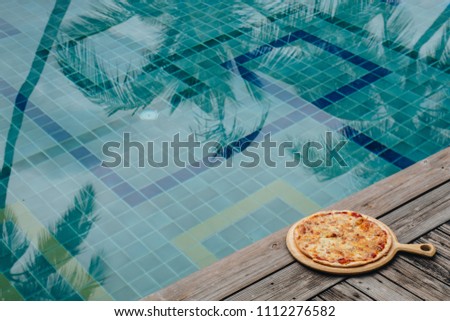 Concept promotional flyer and poster for Restaurants in the hotel or pizzerias in summer, tasty pizza, mozzarella cheese, cherry tomatoes and coconut leaf shadow in swimming pool. tropical style