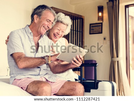 Senior couple using a tablet on the bed