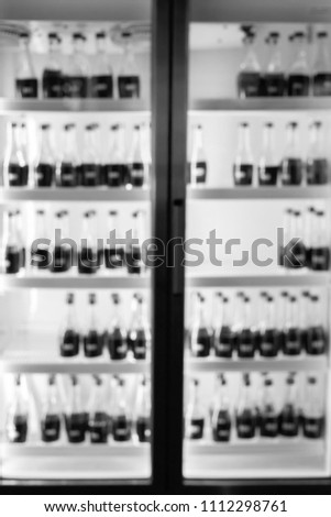 Blur background of bottles of water in the fridge in black and white.