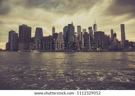Dark vintage color style of Financial District with cloudy sky and river, Manhattan, New York