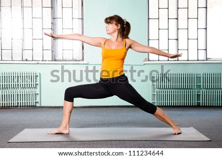 Mature woman exercising yoga in a gym