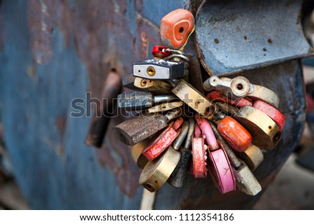 Close-up of red, white and other locks in the form of hearts on the old city bridge, the tradition of lovers on the wedding day