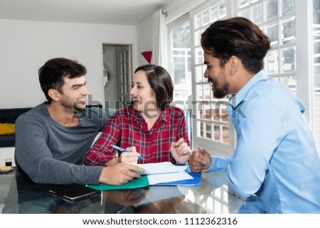 Happy caucasian couple signing contract for own house indoor with real estate agent