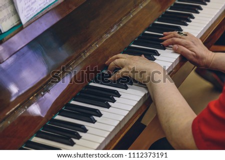 elderly woman playing the old piano