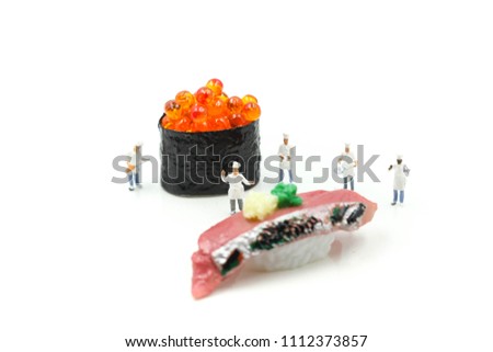 Miniature people : Chef with Salmon egg on sushi nigiri roll on white background.