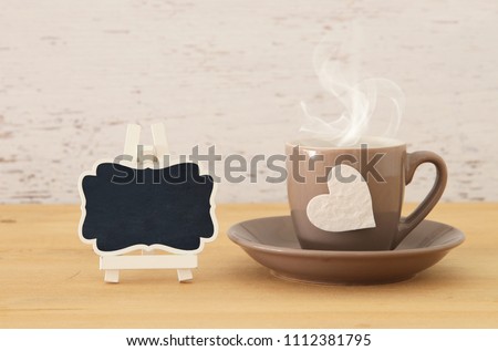 image of coffe cup with heart over wooden table