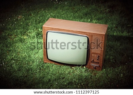 Old retro TV in the grass
