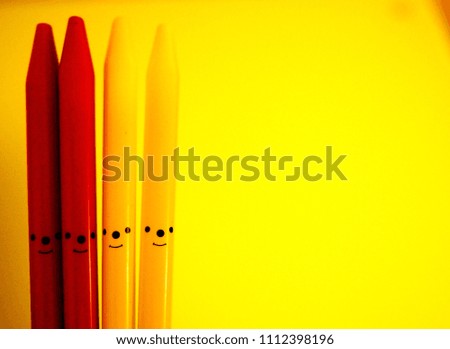 Happy group of pencil faces.Happy colourful pencils on nature background with copy space