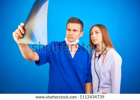 two doctors are looking at an x-ray picture
