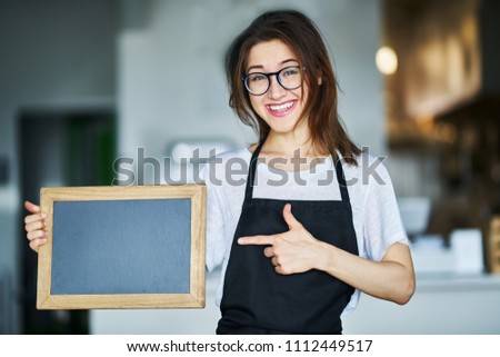 happy waitress holding blank chalkboard sign