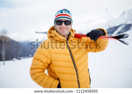 Portrait of sporty man with mountain skis