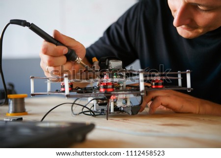 Photo of young man with soldering iron chipping mechanism