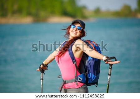 Portrait of happy female athlete with walking sticks on blurred background