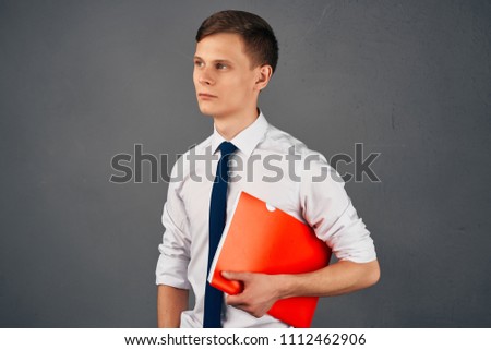 a man with a red folder and a dark tie                           