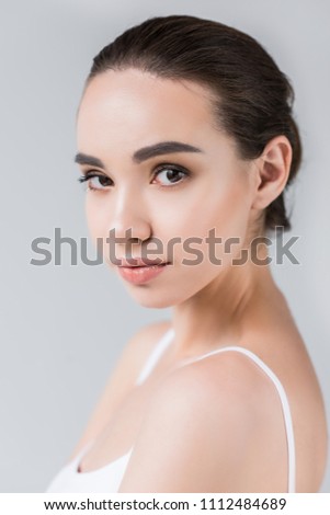 portrait of attractive caucasian woman looking at camera isolated on gray background 