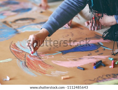 woman is painting with a chalk picture in an art studio on the floor Royalty-Free Stock Photo #1112485643