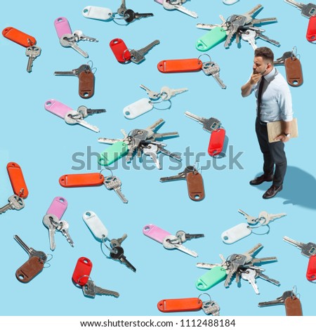 Businessman try to find the key from many keys. Conceptual image of man standing and trying to solve the problem of secrecy. Collage with miniature people. Flat isometric and creative photo. concept