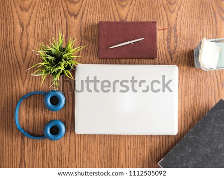 Top view  of businessman laptop on wooden desk , book , headphones ,clipboard 