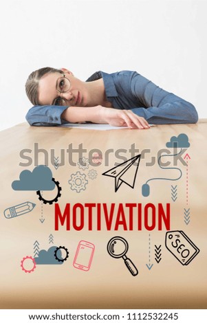 Tired businesswoman lying on table in office with motivation inscription and business icons