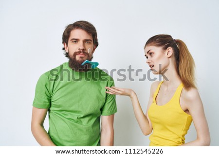  man with cream on his face and comb on his beard, woman                             