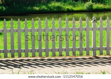 White wooden fence and a beautiful lake.