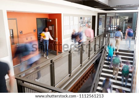 Busy High School Corridor During Recess With Blurred Students And Staff Royalty-Free Stock Photo #1112561213