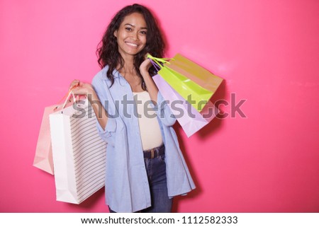 portrait of happiness of asian woman bringing shopping bag on pink background