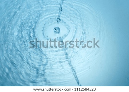 Background of blue clear water in motion with waves, pouring with splash