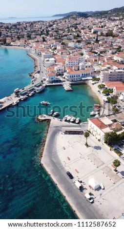 Aerial drone bird's eye view photo of picturesque small harbor in historic and traditional island of Spetses with emerald clear waters, Saronic Gulf, Greece