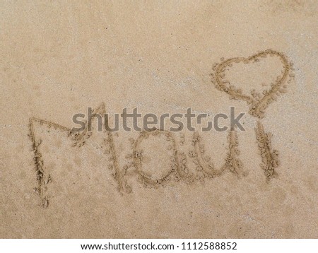 Maui written in the sand of Maui's beach name Maui with a heart