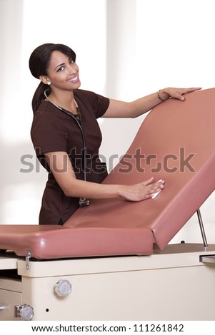 Beautiful nurse cleans an exam chair.