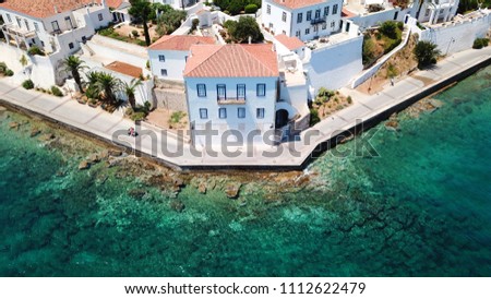 Aerial drone bird's eye view photo of picturesque neoclassic houses built in emerald water waterfront in historic and traditional island of Spetses, Saronic Gulf, Greece