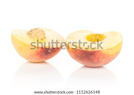 Two halves of yellow peach isolated on white background cross section with a drupe inside
