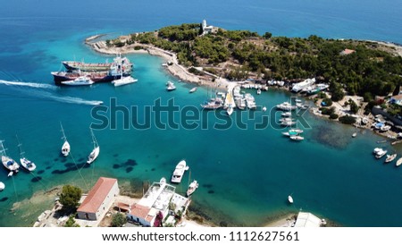 Aerial drone bird's eye view of vegitated area of Kouzounas with Greek Navy lighthouse and small port/shipyard, island of Spetses, Saronic gulf, Greece
