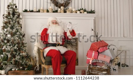 Santa Claus taking merry selfies on his phone