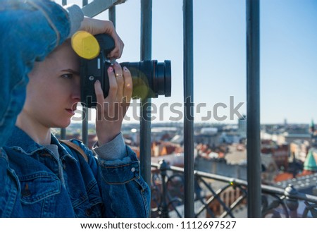 selective focus of young woman taking picture of copenhagen city, denmark