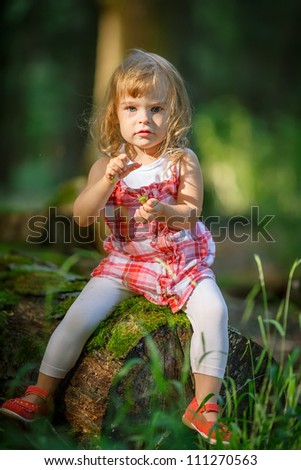 Little girl in the dark green forest