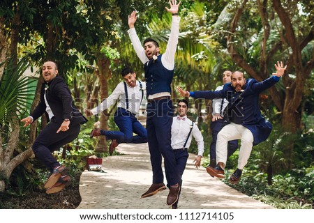Hindu groom and groomsmen have fun jumping outside in the garden Royalty-Free Stock Photo #1112714105