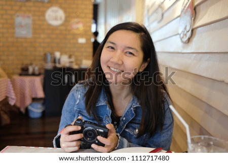 Happy girl with her camera. A camera is an optical instrument for recording or capturing images, which may be stored locally, transmitted to another location, or both.