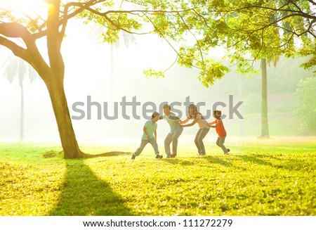 Happy Asian family playing together at outdoor park Royalty-Free Stock Photo #111272279