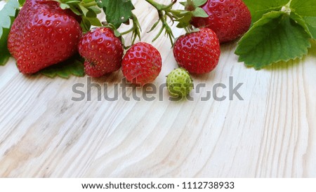 Strawberry. Strawberries on light wood. Blurry photo of a strawberry on light wood
