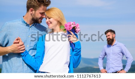 Ex partner watching girl starts happy love relations. New love. Couple in love dating outdoor sunny day, sky background. Ex husband jealous on background. Couple with flowers bouquet romantic date. Royalty-Free Stock Photo #1112767613