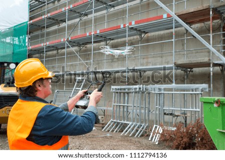 operator of the drone engineer at the construction site manages the flight and makes a video
