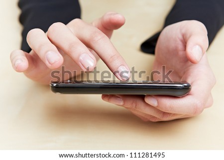 Index finger touching the screen of a smartphone