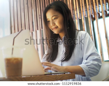 Beautiful woman, the young generation using laptop for online working or special education in a nice internet cafe or coworking space. Technology's impact on people's lives / International women’s day