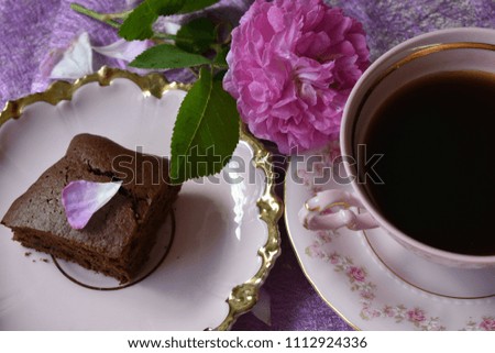 Cake with chocolate on a pink plate with coffee and pink rose.
