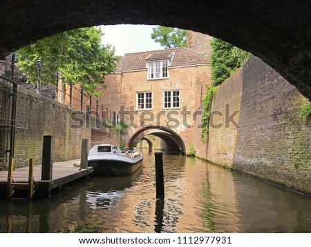 Beautiful canal in Den Bosch wtih a boat, showing a reflection in the water with space for text.  Royalty-Free Stock Photo #1112977931